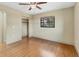 Bedroom featuring a ceiling fan, hardwood floors, closet, and natural light from a window at 480 58Th St, Sarasota, FL 34243