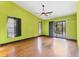 Bright bedroom with hardwood floors, a ceiling fan, and sliding doors leading to the outside at 480 58Th St, Sarasota, FL 34243
