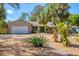Charming single-story home featuring a well-manicured yard, stone accents and a bright green front door at 480 58Th St, Sarasota, FL 34243