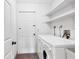 Bright laundry room featuring modern washer and dryer, shelves and white walls at 480 58Th St, Sarasota, FL 34243