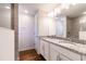 Modern bathroom featuring dual sinks with granite countertops, sleek lighting, and wood floors at 5086 Raven St, North Port, FL 34286