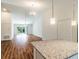 Bright open concept living space with a granite countertop kitchen island and sliding door access to backyard at 5086 Raven St, North Port, FL 34286
