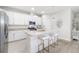 Bright, all-white kitchen boasts granite countertops, stainless steel appliances, and a stylish island with seating at 5235 Coral Reef Way, Bradenton, FL 34211
