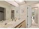 Bright bathroom featuring double sinks, a large mirror, and access to the bedroom at 5729 Avista Dr, Sarasota, FL 34243