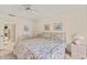 Bright bedroom features floral bedding, matching lamps, and an ensuite bathroom with tile flooring at 5729 Avista Dr, Sarasota, FL 34243