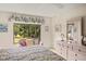 Comfortable bedroom with a large window overlooking the backyard, floral bedding, and a plush cushioned seating area at 5729 Avista Dr, Sarasota, FL 34243