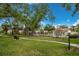 Beautiful community grounds with a well-manicured lawn, mature trees, a community pool, and sidewalks for an active lifestyle at 5729 Avista Dr, Sarasota, FL 34243