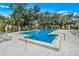 Sparkling community pool surrounded by lounge chairs, lush landscaping, and secure fencing, perfect for relaxation and recreation at 5729 Avista Dr, Sarasota, FL 34243