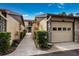 View of garage with rock facade and walkway, landscaped with lush green foliage at 5729 Avista Dr, Sarasota, FL 34243