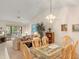 Bright living room featuring a glass dining table, vaulted ceilings, and a sliding glass door to the outdoor area at 5729 Avista Dr, Sarasota, FL 34243