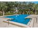 Refreshing community pool surrounded by lounge chairs and mature trees, ideal for enjoying sunny days at 5729 Avista Dr, Sarasota, FL 34243