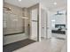 This bathroom has a herringbone patterned shower with glass surround and gray tile floors and bench at 5833 Millennium Silver Ct, Sarasota, FL 34238
