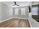Clean bedroom with hardwood floors, natural light, ceiling fan and mounted TV at 5833 Millennium Silver Ct, Sarasota, FL 34238