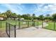 Fenced community dog park with lush green grass, shaded areas, and separate wash station at 5833 Millennium Silver Ct, Sarasota, FL 34238