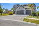 Charming two-story home featuring a three-car garage, landscaped yard, and brick-paved driveway at 5833 Millennium Silver Ct, Sarasota, FL 34238