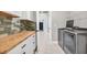 This laundry room features a wood countertop, tile backsplash, and a stainless steel washer and dryer at 5833 Millennium Silver Ct, Sarasota, FL 34238