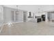 Spacious living area with open floorplan to the kitchen and views of the backyard and staircase at 5833 Millennium Silver Ct, Sarasota, FL 34238