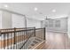 This is a view of the living room from the top of the stairs, with wood floors and a ceiling fan at 5833 Millennium Silver Ct, Sarasota, FL 34238