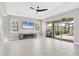 Bright living room features large windows, ceiling fan, and sliding glass doors to the screened lanai at 5833 Millennium Silver Ct, Sarasota, FL 34238