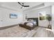 This main bedroom has wood-look floors, a decorative ceiling fan, and a mounted television at 5833 Millennium Silver Ct, Sarasota, FL 34238