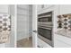 Pantry with shelving next to a double oven and wine rack in this bright, updated kitchen at 5833 Millennium Silver Ct, Sarasota, FL 34238