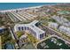 An aerial shot displaying a modern condominium complex, pool, tennis courts, and a marina at 5855 Midnight Pass Rd # 204, Sarasota, FL 34242