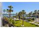 Enjoy the outdoor scenery in this gorgeous backyard featuring lush green grass, palm trees, and waterfront views at 5855 Midnight Pass Rd # 204, Sarasota, FL 34242