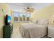 The bedroom has a patterned ceiling fan, bright natural light, and ample storage in the bedside tables at 5855 Midnight Pass Rd # 204, Sarasota, FL 34242