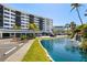 Beautiful building exterior showcasing a well-manicured lawn, waterfront views and a peaceful pond at 5855 Midnight Pass Rd # 204, Sarasota, FL 34242