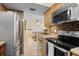 The kitchen features stainless steel appliances, custom cabinets, tiled backsplash, and a pass-through to the dining area at 5855 Midnight Pass Rd # 204, Sarasota, FL 34242