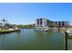 Scenic marina featuring various boats docked, a well-maintained building, and lush palm trees along the waterfront at 5855 Midnight Pass Rd # 204, Sarasota, FL 34242
