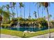Scenic pond with lush greenery, a charming waterfall, and swaying palm trees creating a tranquil environment at 5855 Midnight Pass Rd # 204, Sarasota, FL 34242