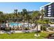 Aerial view of a sparkling community pool surrounded by palm trees and lounge chairs at 5855 Midnight Pass Rd # 204, Sarasota, FL 34242