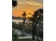 Golden sunset through palm trees with a serene view of the water and sky at 5855 Midnight Pass Rd # 204, Sarasota, FL 34242