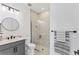 Modern bathroom with a glass-enclosed shower, gray vanity, sleek fixtures, and neutral tile at 6260 Fish Eagle Ct, Nokomis, FL 34275