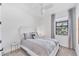 Cozy bedroom with large window providing natural light, white headboard, stylish comforter and neutral colored walls at 6260 Fish Eagle Ct, Nokomis, FL 34275