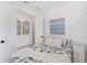 Bright bedroom with a comfortable bed, white walls, coastal art, and ensuite bathroom with a closet at 6260 Fish Eagle Ct, Nokomis, FL 34275