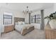 Serene bedroom with a decorative chandelier, plush carpet, and ample natural light through large windows at 6260 Fish Eagle Ct, Nokomis, FL 34275