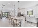 Open-concept kitchen featuring a large island with seating, white cabinets, and modern stainless steel appliances at 6260 Fish Eagle Ct, Nokomis, FL 34275