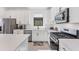 Bright, modern kitchen with white cabinets, stainless steel appliances, and a gas range cooktop at 6260 Fish Eagle Ct, Nokomis, FL 34275