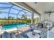Relax in this screened lanai with a pool, lake views, dining area, and comfortable seating, perfect for entertaining at 6260 Fish Eagle Ct, Nokomis, FL 34275