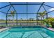 Sparkling screened pool with lush landscaping offers a private backyard oasis with serene water views at 6260 Fish Eagle Ct, Nokomis, FL 34275