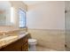 Bright bathroom features stone tiles, a vanity with a granite top, decorative window and a glass shower enclosure at 6308 Caracara St, Sarasota, FL 34241