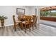 Dining room with a wooden dining table, six chairs, and sliding glass doors leading to an outdoor screened patio at 6308 Caracara St, Sarasota, FL 34241