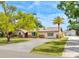 Charming ranch-style home with a long driveway, well-maintained lawn, mature trees, and a separate garage in the back at 6308 Caracara St, Sarasota, FL 34241