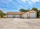 Detached four-car garage with white doors and ample parking space, set against a bright blue sky at 6308 Caracara St, Sarasota, FL 34241