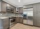 Beautiful kitchen featuring gray cabinets, stainless steel appliances, and a stylish backsplash with modern countertops at 6308 Caracara St, Sarasota, FL 34241