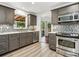 Well-lit kitchen featuring gray cabinets, stainless steel appliances, stylish backsplash, and a sink under a window at 6308 Caracara St, Sarasota, FL 34241
