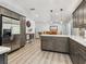 Bright kitchen featuring gray cabinets, stainless steel appliances, an island with white countertops, and wood-look flooring at 6308 Caracara St, Sarasota, FL 34241