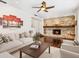 Living room features a stone fireplace, hardwood floors, light-colored furniture, and a ceiling fan at 6308 Caracara St, Sarasota, FL 34241